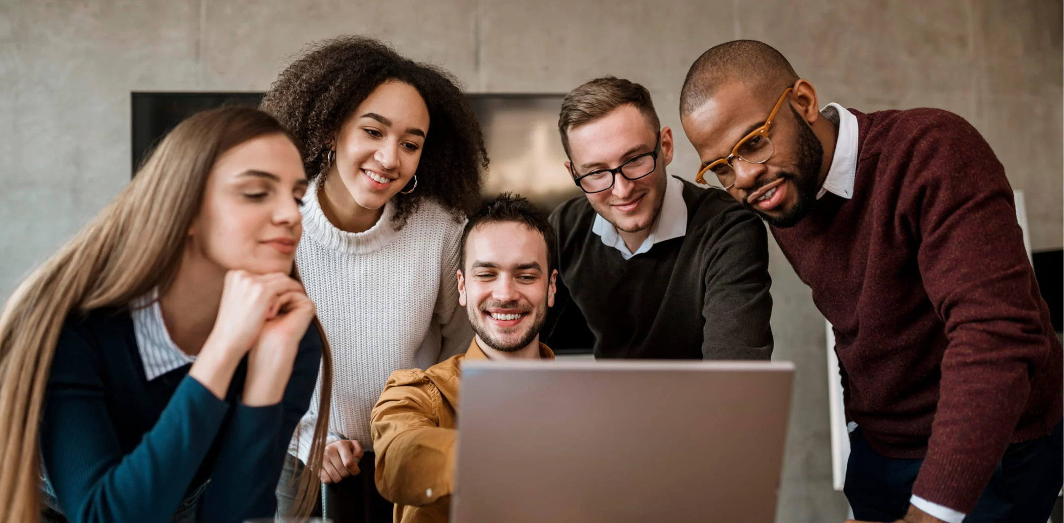 people gathered by a laptop